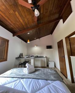 1 dormitorio con 1 cama grande y techo de madera en Chalé Mantiqueira, en Cunha