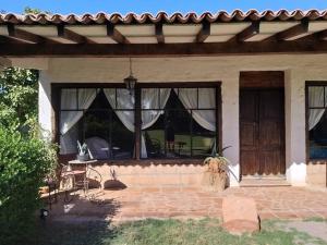Cette maison dispose d'une terrasse avec une table et des fenêtres. dans l'établissement Ranchito La Querencia, à Mexicali