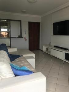 ein Wohnzimmer mit einem weißen Sofa und einem Flachbild-TV in der Unterkunft Lindo apartamento com vista para o mar in Matinhos