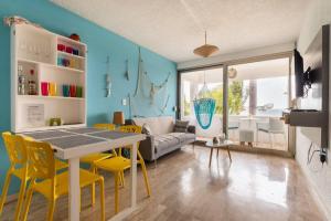 a living room with a table and yellow chairs at Departamento frente al Mar - Kiara in Canc&uacute;n