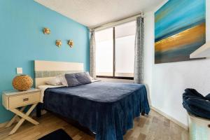 a bedroom with a bed and a window at Departamento frente al Mar - Kiara in Canc&uacute;n