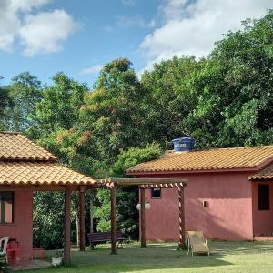 una casa con un pabellón y un banco en un patio en Pousada Recanto do Sossego- Serra da Canastra, en Vargem Bonita