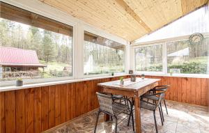 a screened in porch with a table and chairs at Lovely Home In Jedwabno With Kitchen in Jedwabno