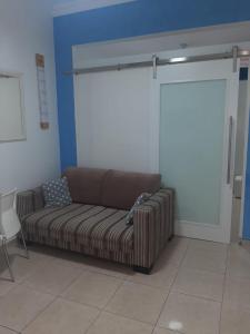 un sofá marrón sentado en una habitación con una pared en Real Apartments 063 - Apartamento completo em Copacabana, próximo a Praia, en Río de Janeiro