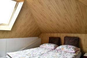 a bed in a room with a wooden ceiling at Wczasy u Gospodarza na Kaszubach in Kistowko