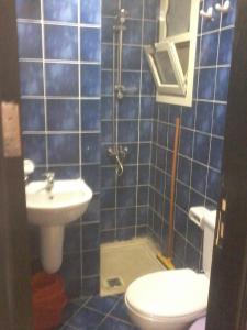 a blue tiled bathroom with a toilet and a sink at Chalets in Porto Sharm in Sharm El Sheikh