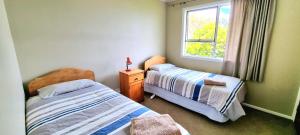 a bedroom with two beds and a window at Coromandel Coast Haven in Tapu