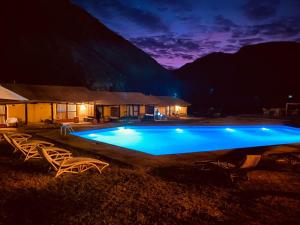 a swimming pool at night with chairs and a building at Aruma Codpa in Codpa