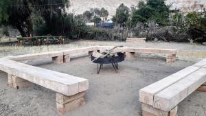 a fire pit with two benches and a grill at Aruma Codpa in Codpa