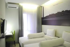 Cette chambre comprend 2 lits, une table et une fenêtre. dans l'établissement Vio Westhoff, à Bandung