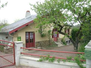 een klein huis met een rood hek ervoor bij Gîte Hérisson, 3 pièces, 5 personnes - FR-1-489-15 in Hérisson