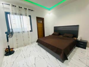 a bedroom with a bed and a green light at Chez El Hadji et Hamidou in Dakar