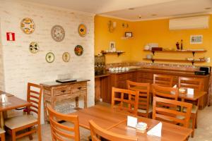 a restaurant with yellow walls and wooden tables and chairs at Hotel Valparaíso - Metrô Paraíso e 800m da Av Paulista in São Paulo