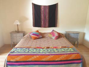 a bedroom with a bed with two tables and a blanket at Aruma Codpa in Codpa