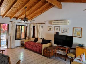 een slaapkamer met een bed en een flatscreen-tv bij La casa de Chiqui in Mendoza