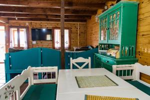 Drvene kuće ŠUŠKA في Zaovine: غرفة طعام مع أثاث أخضر وبيضاء وطاولة