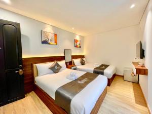 Postel nebo postele na pokoji v ubytování Carnival Hotel - Đà Lạt