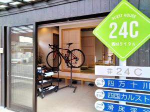 uma bicicleta num suporte para bicicletas numa vitrine em ゲストハウス 西村サイクル（24C） em Izume