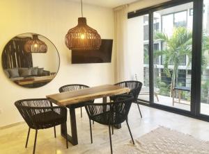 uma sala de jantar com uma mesa, cadeiras e um espelho em 206 Amena Boho Modern Oasis Best Location&Fast WIFI em Tulum