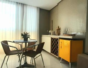 a kitchen with a table and chairs and a table and a counter at Ap Luxo e Requinte em Guarapari in Guarapari