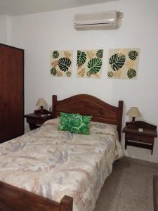 um quarto com uma cama com 2 mesas e uma ventoinha em Aimara apartamentos y habitaciones em Santa Rosa de Calamuchita