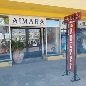 uma frente de loja com um sinal em frente em Aimara apartamentos y habitaciones em Santa Rosa de Calamuchita