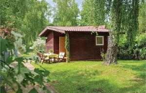 a small wooden cabin with a table in the yard at Lovely Home In Morag With Kitchen in Pojezierce