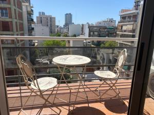 un par de sillas y una mesa en el balcón en Hermoso departamento sobre Cabildo y contrafrente en Buenos Aires