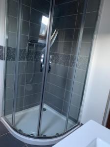 La salle de bains est pourvue d'une douche avec une porte en verre. dans l'établissement Voltaire 7 hyper-centre, à Saint-Quentin