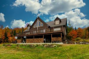 a large wooden house on a hill with trees at The Maine Glades in Newry