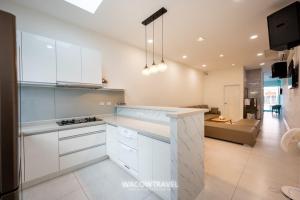 a kitchen with white cabinets and a living room at SMilE WAVE in Xiaoliuqiu