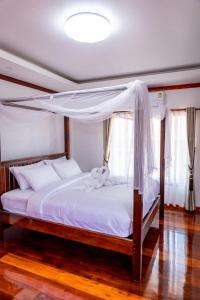 1 dormitorio con cama con dosel y sábanas blancas en HR Resort 