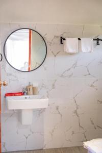 Baño blanco con espejo y lavabo en HR Resort 
