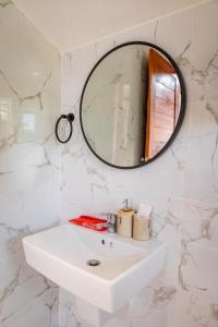 Baño blanco con espejo y lavabo en HR Resort 