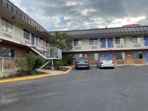 two cars parked in a parking lot in front of a hotel at Travelodge by Wyndham San Antonio Lackland AFB North in San Antonio