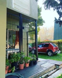 a red car parked next to a house with plants at Mar de Cobo casa en alquiler temporario in Mar de Cobo