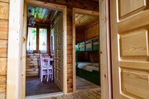 una puerta que conduce a un dormitorio en una cabaña de madera en Drvene kuće ŠUŠKA, en Zaovine