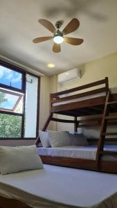 a bedroom with two bunk beds and a ceiling fan at Beachfront Vacation Villa with Infinity Pool in Batangas City