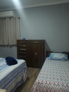 a bedroom with two beds and a dresser in it at Apartamento São Vicente in São Vicente