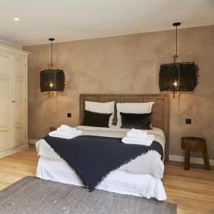 - une chambre avec un grand lit et des oreillers noirs et blancs dans l'établissement Les pénates bordelaises - Maison d'hôtes - Guesthouse, à Bordeaux