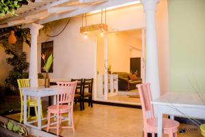 a dining room with pink and yellow chairs and a table at Blooming polhena in Matara