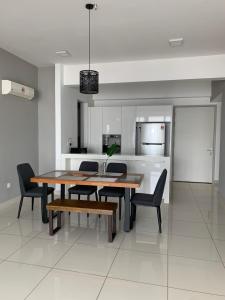 a dining room table and chairs in a kitchen at Jazz Service Suites 2 bedroom 35-1 by Yen's Sojourn in Bagan Jermal