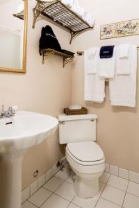 a bathroom with a toilet and a sink and towels at The Bishop Hotel in Port Townsend