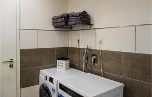 a bathroom with a washing machine in a room at 1 Bedroom Gorgeous Home In Heckenmnster 