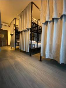 Cette chambre comprend 2 lits superposés avec des rideaux. dans l'établissement HideSeek Hostel Vientiane Thai embassy, à Vientiane