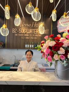 a woman sitting at a counter with flowers and lights at Elene Phu Quoc in Phú Quốc