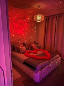 a bedroom with a large bed with red flowers on it at Suite Jacuzzi Giverny Paris in Freneuse +53 photos