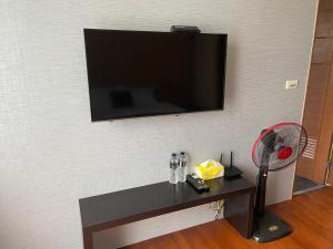a tv on a wall with a table with a fan at Eli House in Toucheng
