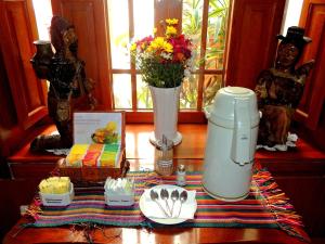 a table with a blender and a vase with flowers at Lima Wari Hotel Boutique in Lima