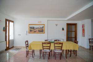 ein Esszimmer mit einem gelben Tisch und Stühlen in der Unterkunft CASA DE ANDRE' in Montesano Salentino